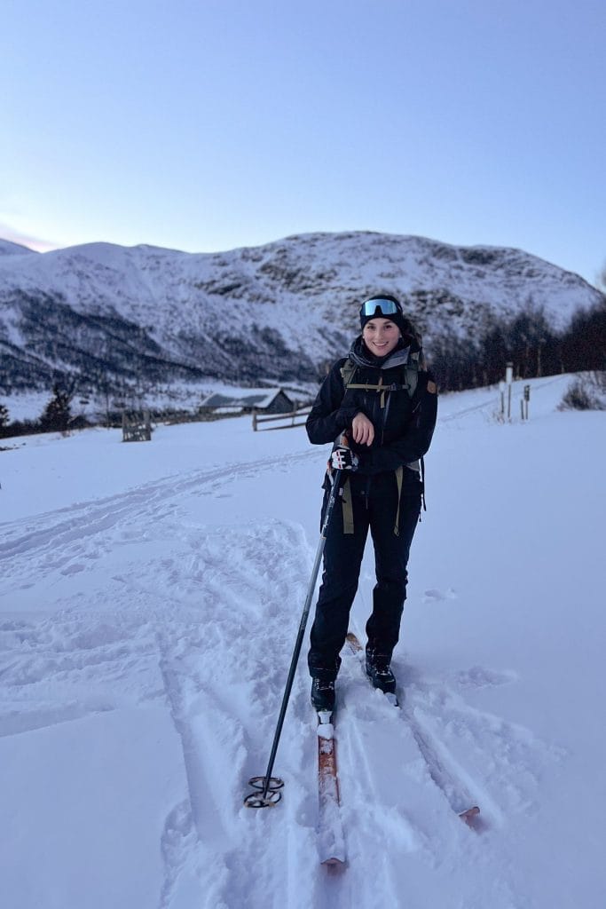 Woman on backcountry skis in a snowy mountain landscape in Norway