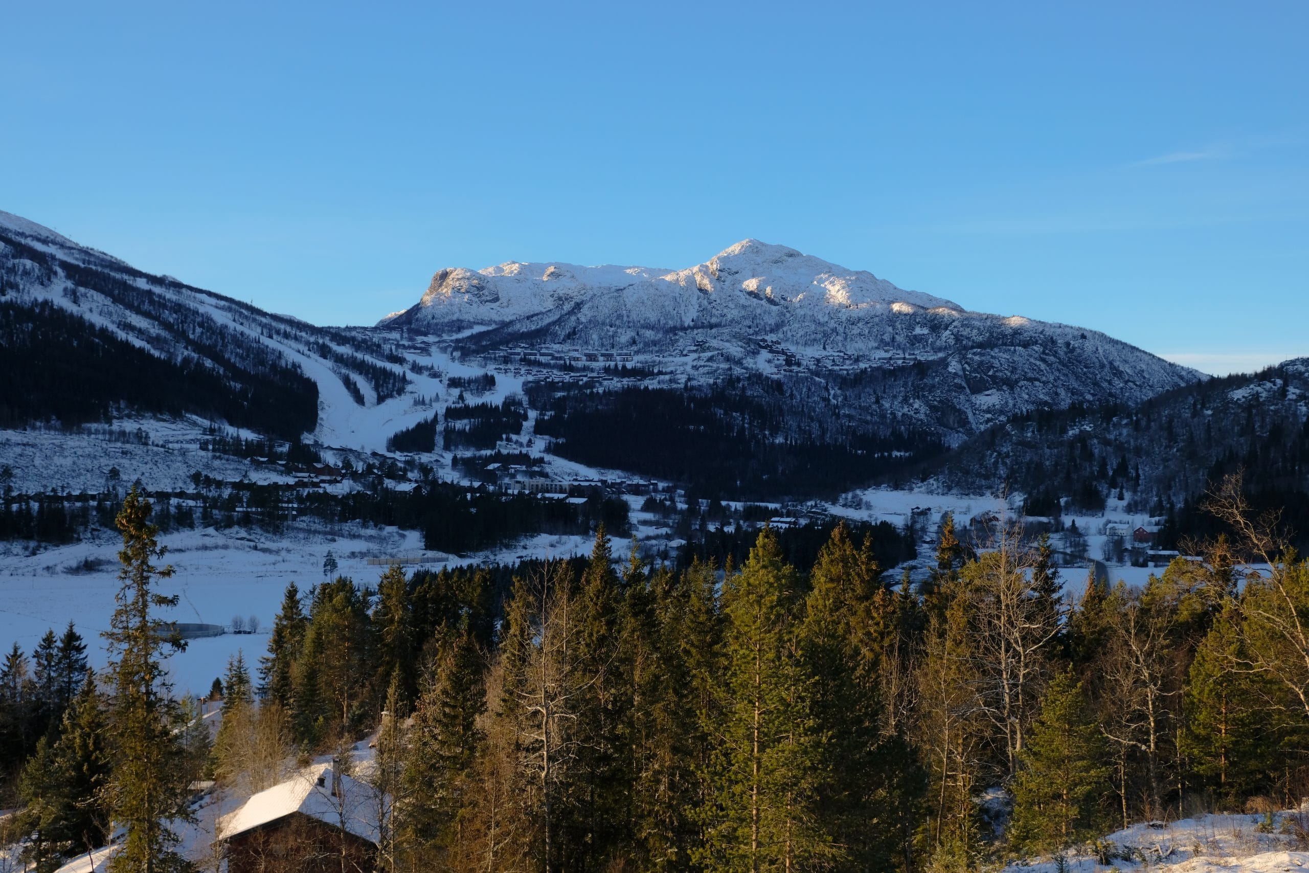 Sunny December view over Hemsedal Ski Center with snow-covered slopes during the Hemsedal ski season opening.