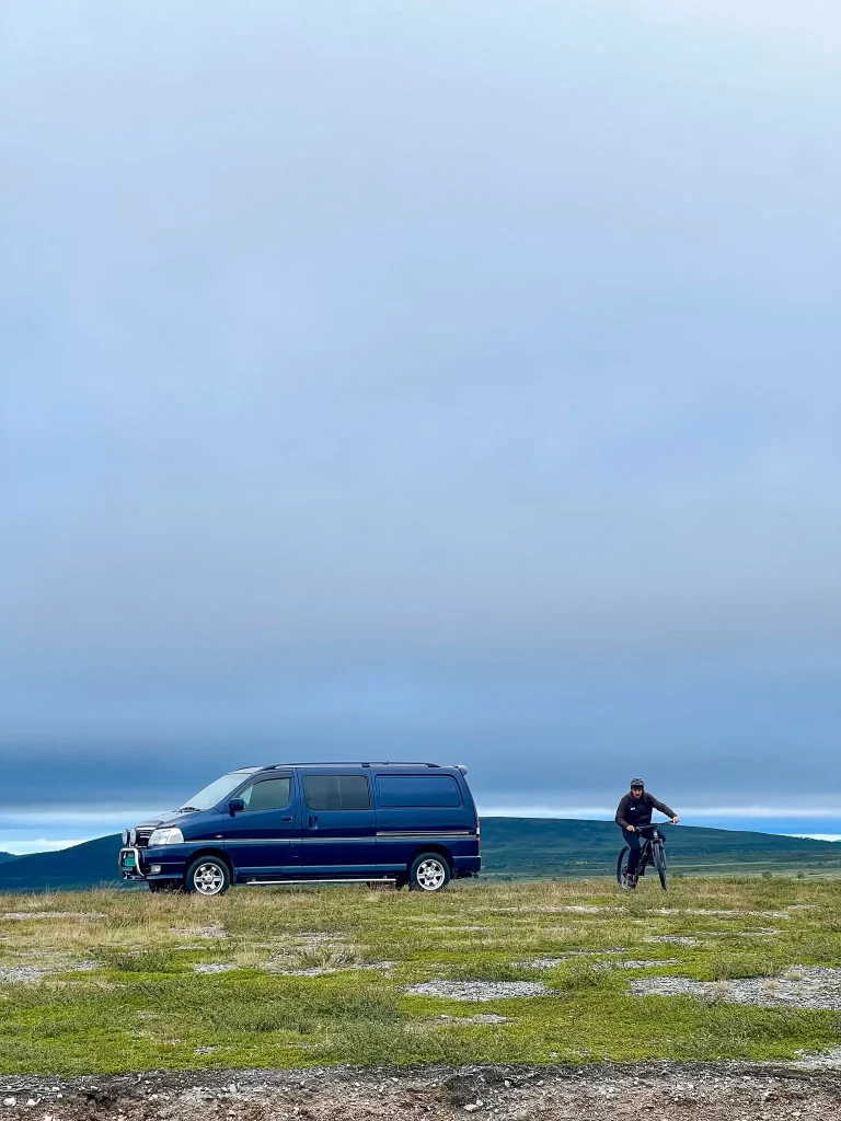 Calm wild camping spot with a blue van in the Norwegian mountains