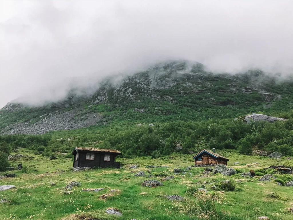 Small mountain cabins beneath low clouds in Norway