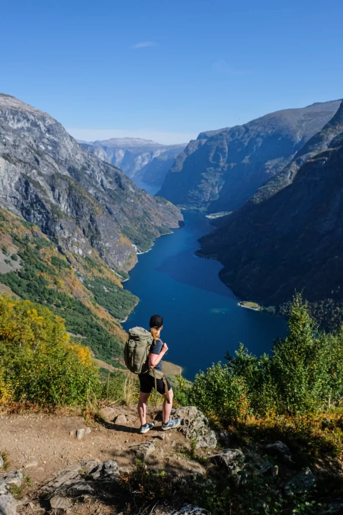 Hiker overlooking a fjord landscape in Norway during a summer hike