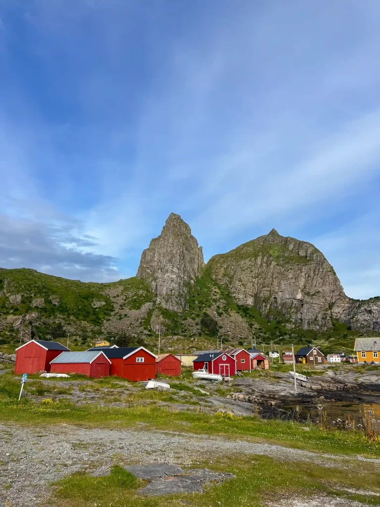 Consultations Red houses beneath steep rocky mountains in a coastal village in Norway