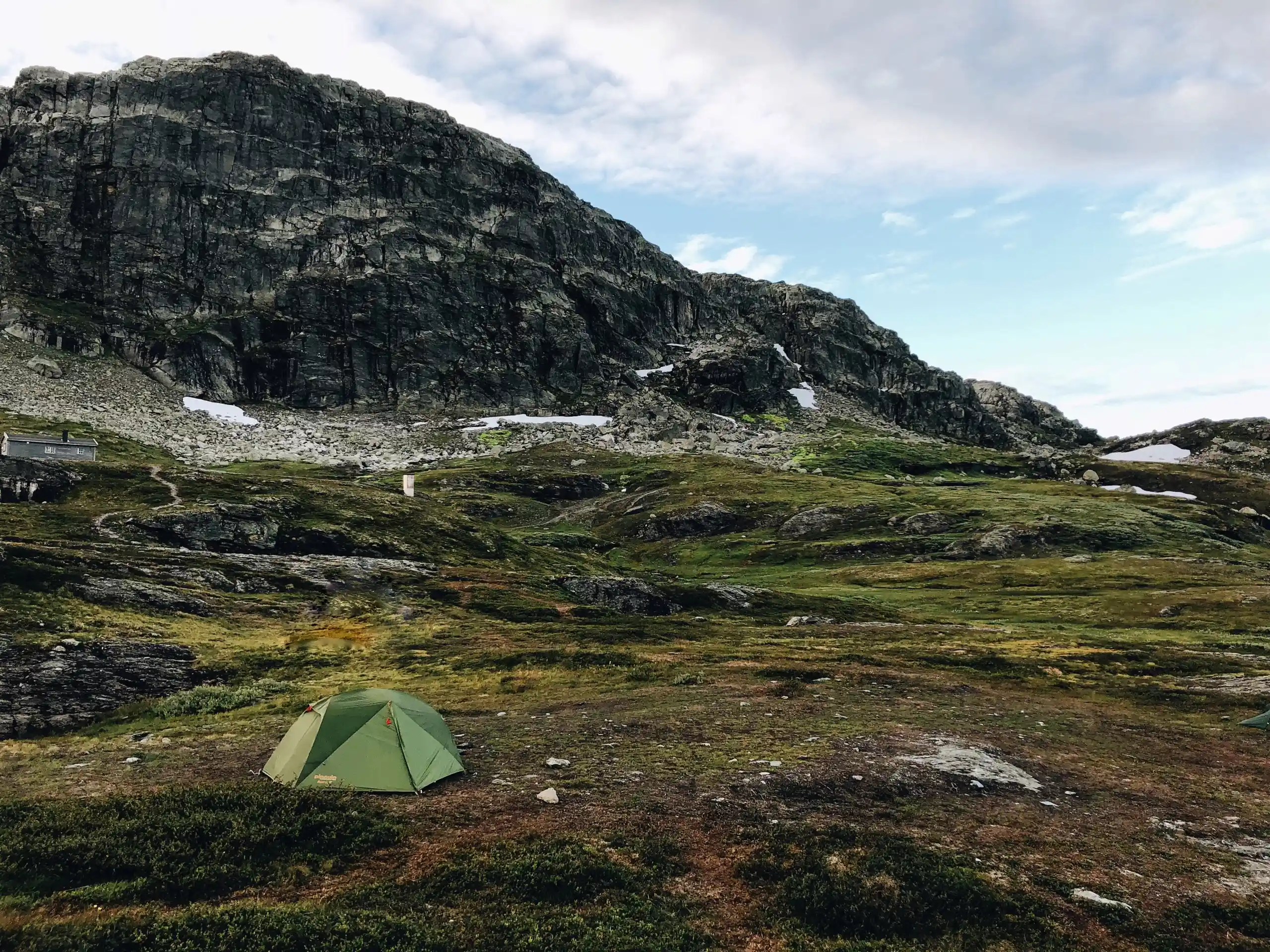 Green tent pitched in the Norwegian mountains, illustrating the right to roam in Norway and wild camping on uncultivated land