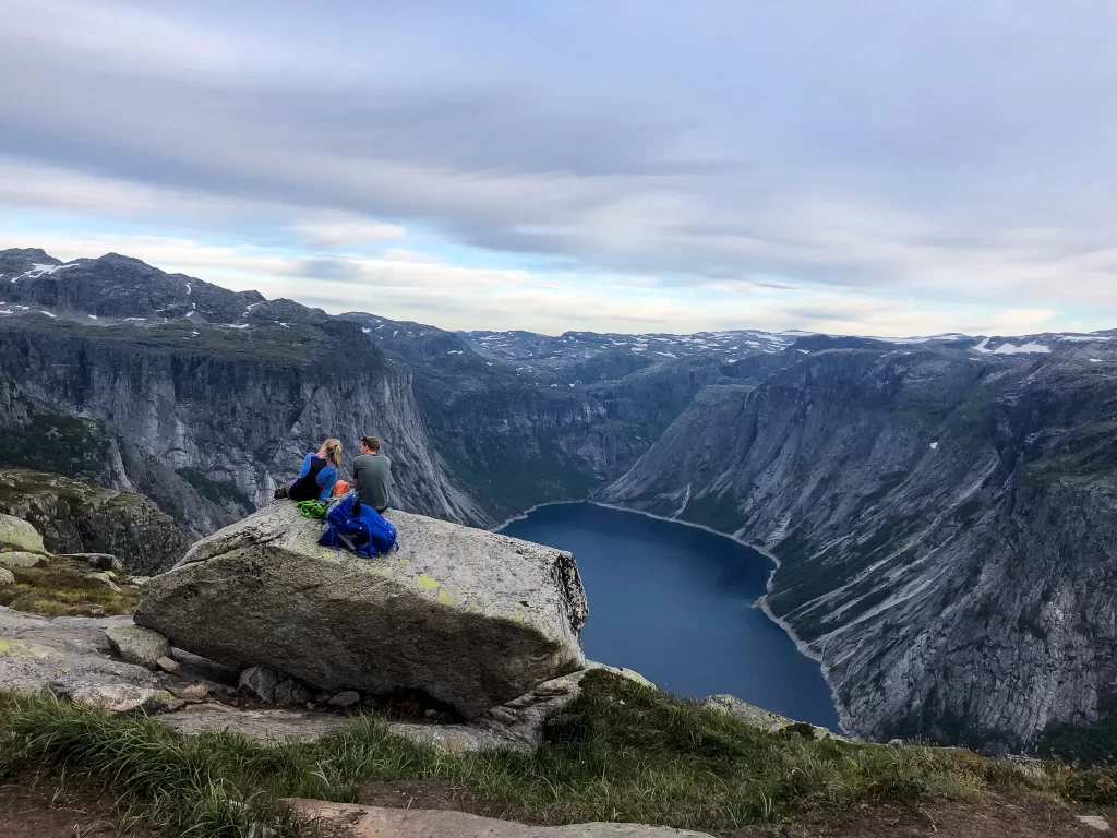 Hikers taking a break above Ringedalsvatnet lake during the long Trolltunga hike in Norway.