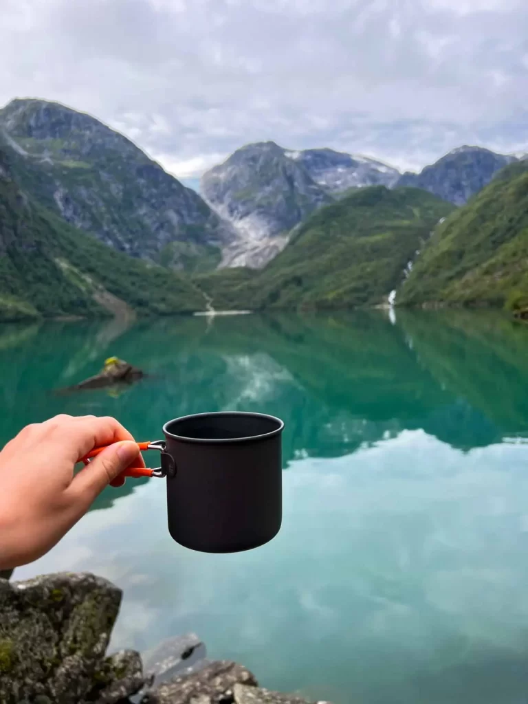 Cup of coffee overlooking Bondhusvatnet lake and surrounding mountains