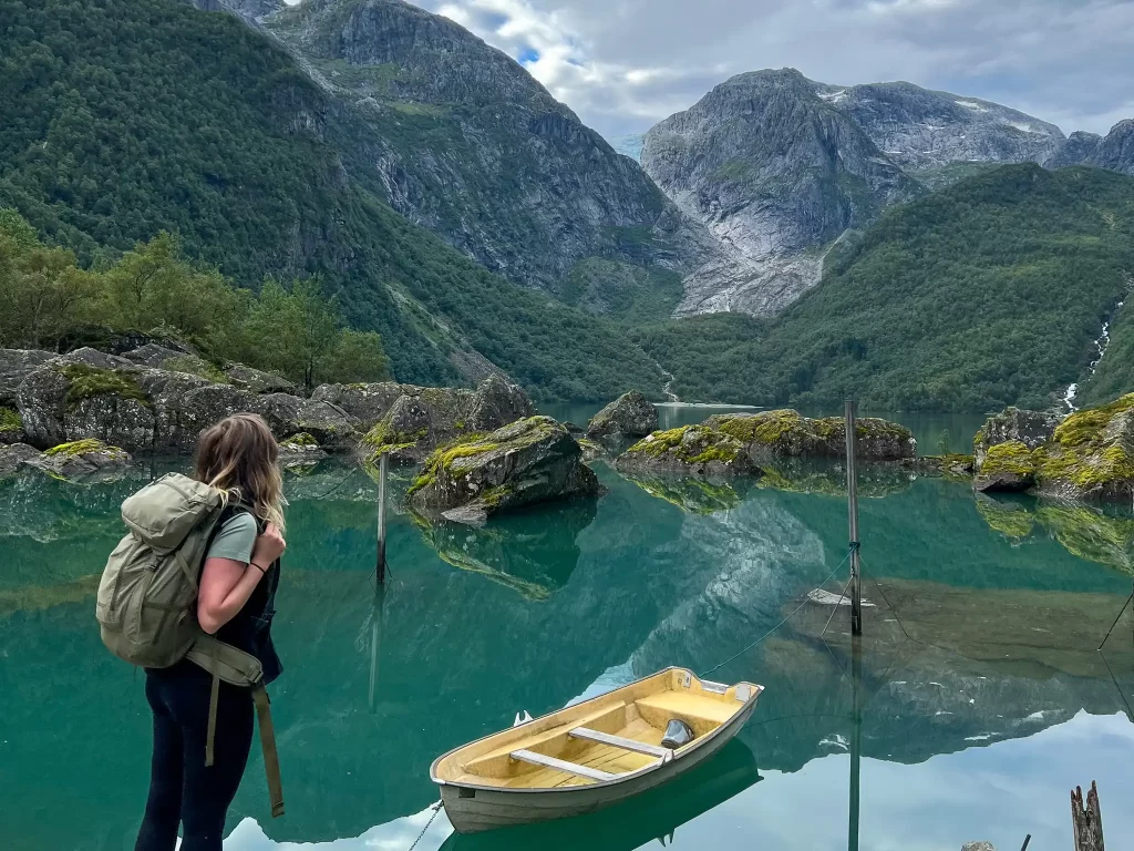Hiker overlooking turquoise Bondhusvatnet lake and the surrounding mountains